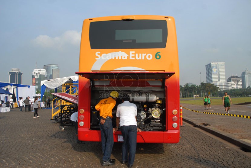   Sejumlah tamu undangan melihat bagian mesin Bus Scania Euro 6 saat melakukan uji coba melintas di Jalan Jendral Sudirman, Jakarta Pusat, Kamis (8/5). (Republika/Rakhmawaty La'lang)