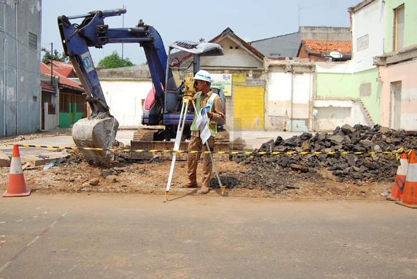  Petugas dari Kementerian Pekerjaan umum mengukur jarak untuk pembangunan sodetan Kali Ciliwung ke Kanal Banjir Timur di Jalan Otista III, Jakarta Timur, Jumat (9/5). (Foto: Raisan Al Farisi)