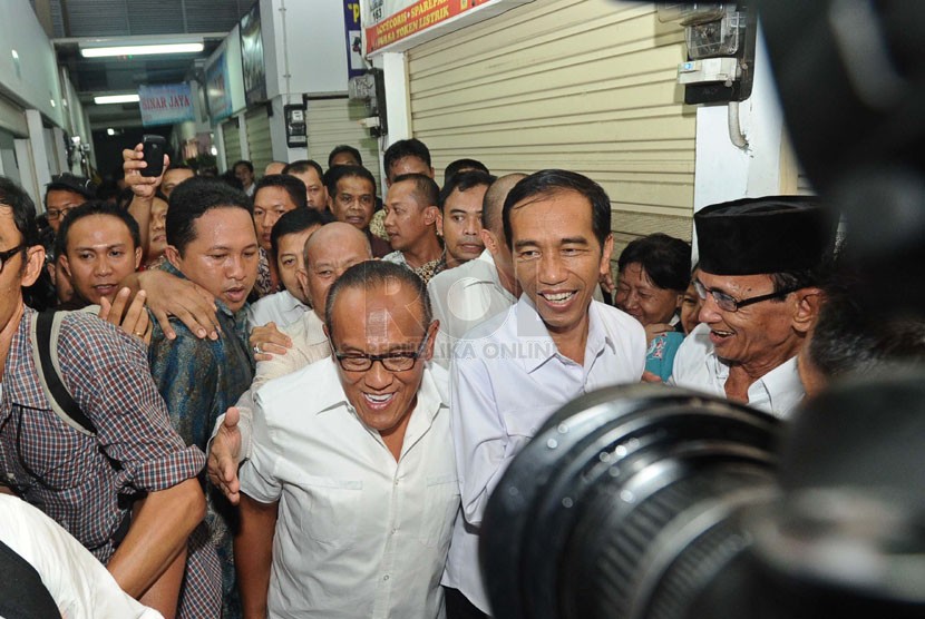 Capres dari PDIP Joko Widodo bersama Ketua Umum DPP Partai Golkar Aburizal Bakrie saat mengunjungi pasar Gembrong di Cempaka Putih, Jakarta, Selasa (13/5). (Republika/Tahta Aidilla)
