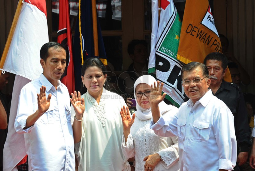   Pasangan Capres-cawapres PDIP Joko Widodo (kiri) dan Jusuf Kalla (kanan) beserta para istri menyapa publik saat deklarasi pasangan capres di Gedung Joang 45, Jakarta, Senin (19/5). (Republika/Tahta Aidilla)