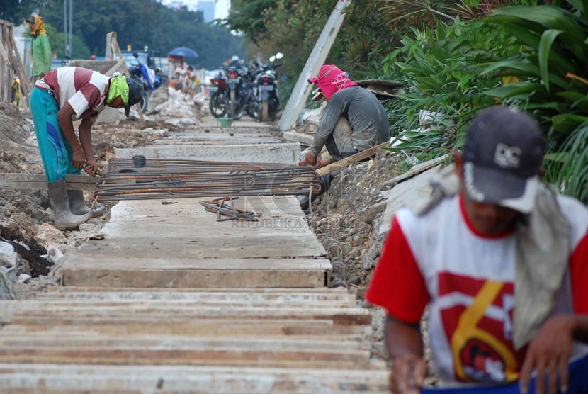  Sejumlah pekerja memasang besi beton untuk pembuatan saluran air baru di kawasan Kelapa Gading, Jakarta Utara, Rabu (28/5).  (foto : Raisan Al Farisi)