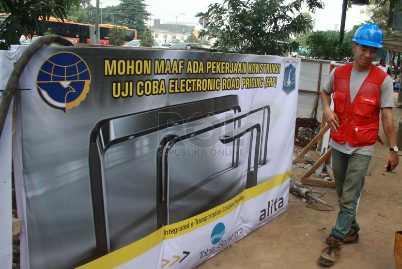   Pekerja memasang papan penutup saat melakukan pengeboran untuk pemasangan gate (gerbang) sensor On Board Unit (OBU) Elektronic Road Pricing (ERP) di Jalan Sudirman, Jakarta, Jumat (30/5). (Republika/ Yasin Habibi)