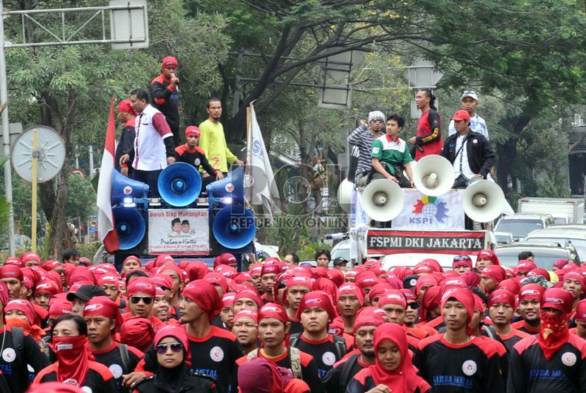 Massa buruh Konfederasi Serikat Pekerja Indonesia (KSPI) se-Jabodetabek melakukan aksi long march saat demo di kantor Kemenkumham, Jakarta, Kamis (19/6).  (Republika/Tahta Aidilla)