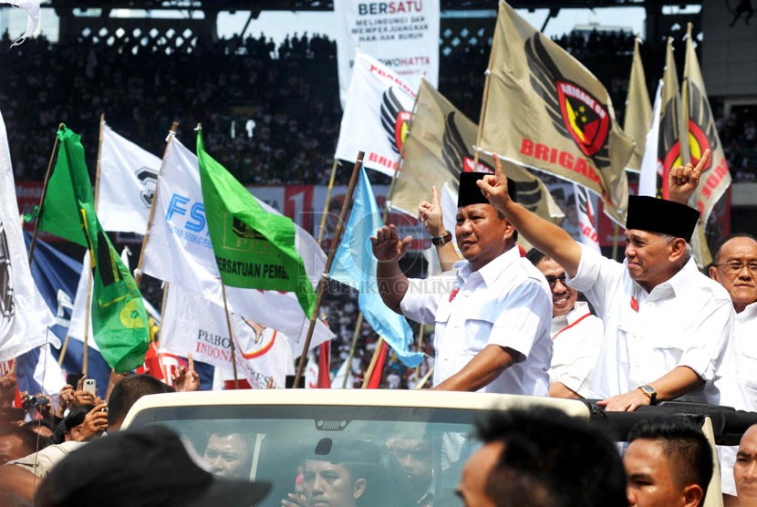   Pasangan Capres dan Cawapres nomor urut satu Prabowo serta-Hatta Rajasa melambaikan tangan menyapa simpatisan saat masuk area Kampanye Akbar di Gelora Bung Karno, Jakarta, Ahad (22/6). (Republika/ Wihdan)
