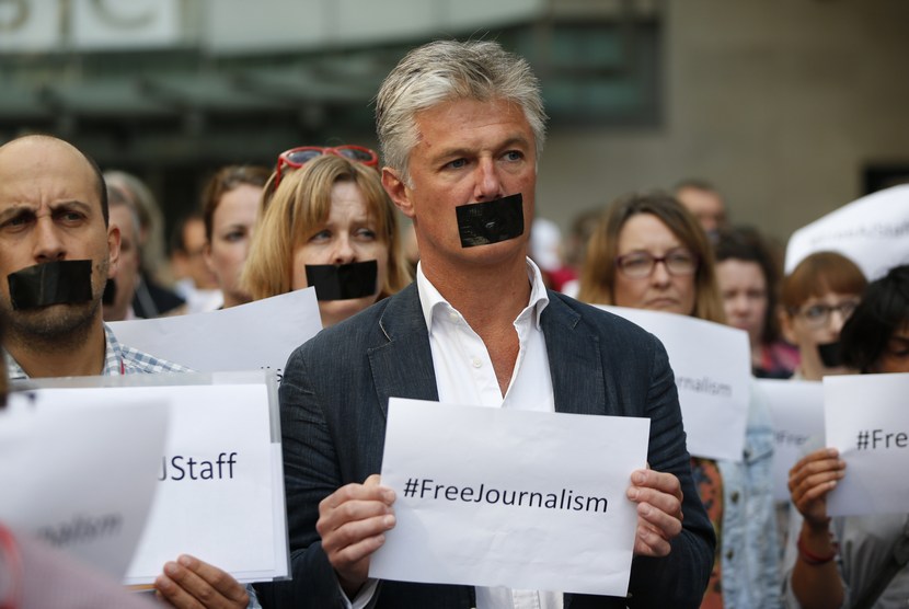  Sejumlah wartawan dan staf BBC, mengenakan pita hitam di mulut mereka sebagai aksi protes di pusat kota London, Selasa, (24/6), untuk mendukung wartawan Al-Jazeera English yang ditahan aparat Mesir. (AP/Lefteris Pitarakis)