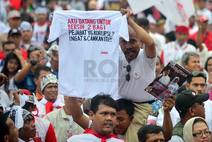  Pendukung pasangan capres Jokowi-Jk mengikuti pengukuhan satgas relawan Jokowi-JK antikecurangan dan politik uang di Parkir Timur Senayan, Jakarta, Kamis (26/6).  (Republika/Agung Supriyanto)