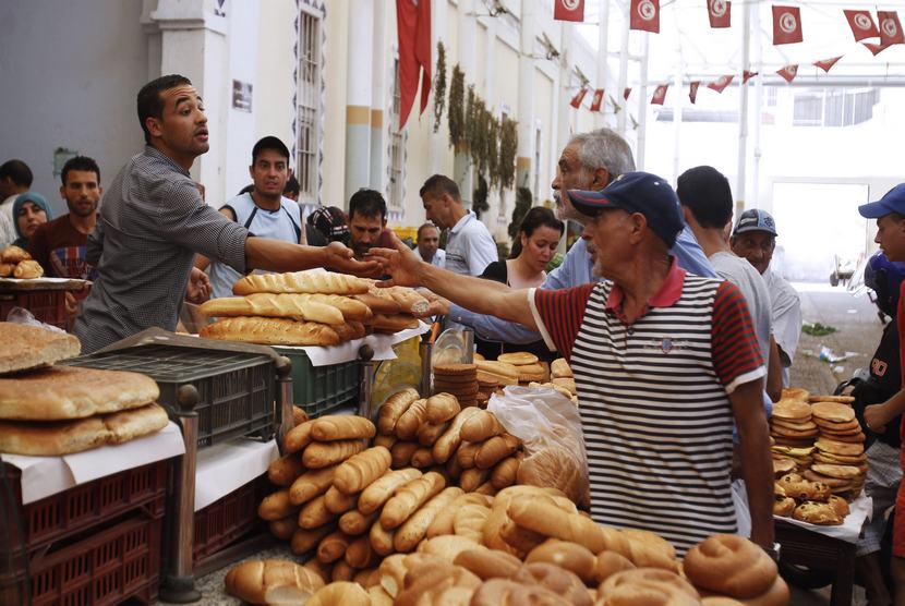   Warga membeli roti pada hari pertama bulan suci Ramadhan, di pusat kota Tunisia, Ahad (29/6).  (Reuters/Zoubeir Souissi)