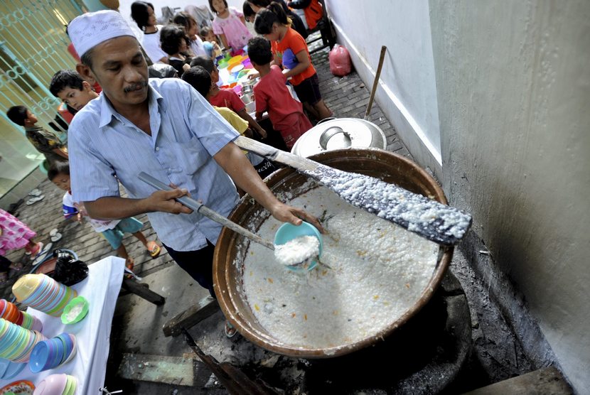  Pengurus masjid menuangkan bubur India ke dalam mangkuk untuk hidangan berbuka puasa, di Masjid Jami Pekojan Semarang, Senin (30/6).   (Antara/R. Rekotomo)