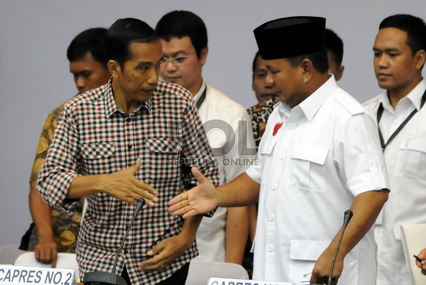 Calon presiden nomor urut satu Prabowo Subianto (kanan) dan calon presiden nomor urut dua Joko Widodo (kiri) berjabat tangan usai pengumuman laporan harta kekayaan di Kantor KPU, Jakarta, Selasa (1/7).(Republika/Aditya Pradana Putra). 