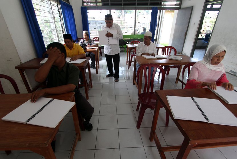  Guru mengaji Khairil Anwar (tengah) mengajarkan bacaan ayat suci Al Quran kepada para tuna netra dengan menggunakan huruf braille saat menggelar tadarusan di Medan, Sumut, Kamis (3/7). (Antara/Septianda Perdana)