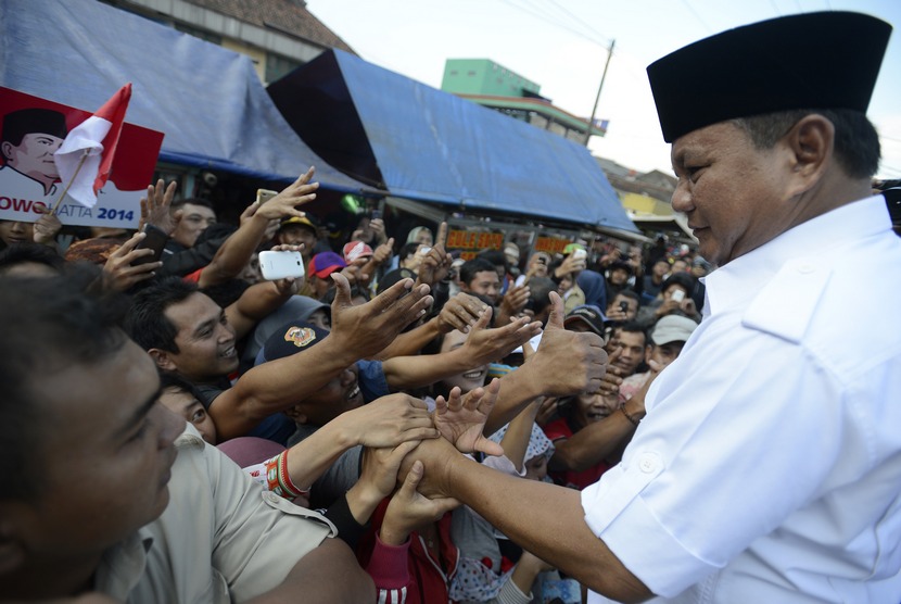  Capres Prabowo Subianto menyapa warga saat mengunjungi pasar Ciparay, Bandung, Jabar, Kamis (3/7).   (Antara/Prasetyo Utomo)