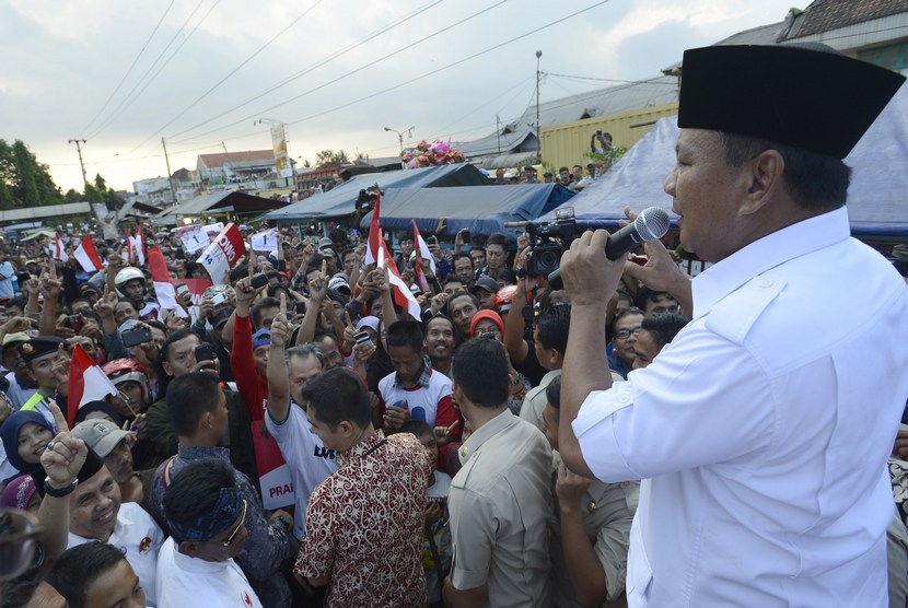   Capres Prabowo Subianto menyampaikan orasi saat mengunjungi pasar Ciparay, Bandung, Jabar, Kamis (3/7). (Antara/Prasetyo Utomo)