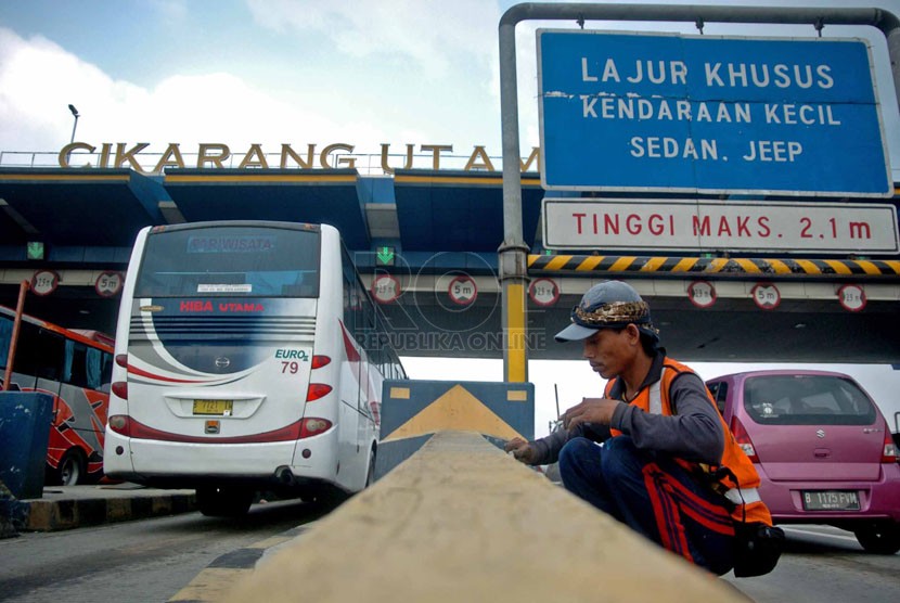   Pekerja menyelesaikan proses pengecatan yang dilakukan di gerbang pintu tol Cikarang Utama, Jawa Barat, Senin (7/7). (Republika/Raisan Al Farisi)