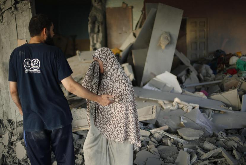Seorang wanita Palestina menangis melihat rumahnya yang hancur akibat serangan udara Israel, di Kota Gaza, baru-baru ini.  (Reuters/Mohammed Salem)