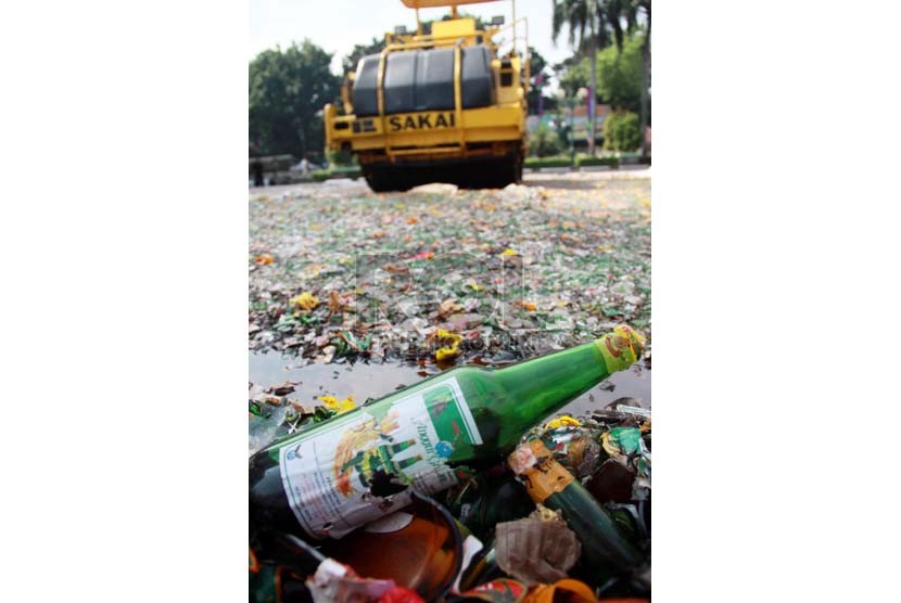  Alat berat memusnahkan belasan ribu botol minuman keras (miras) hasil operasi sepanjang bulan Ramadan 1435 H di halaman kantor Walikota Administrasi Jakarta Selatan, Rabu (23/7).  (Republika/ Yasin Habibi)