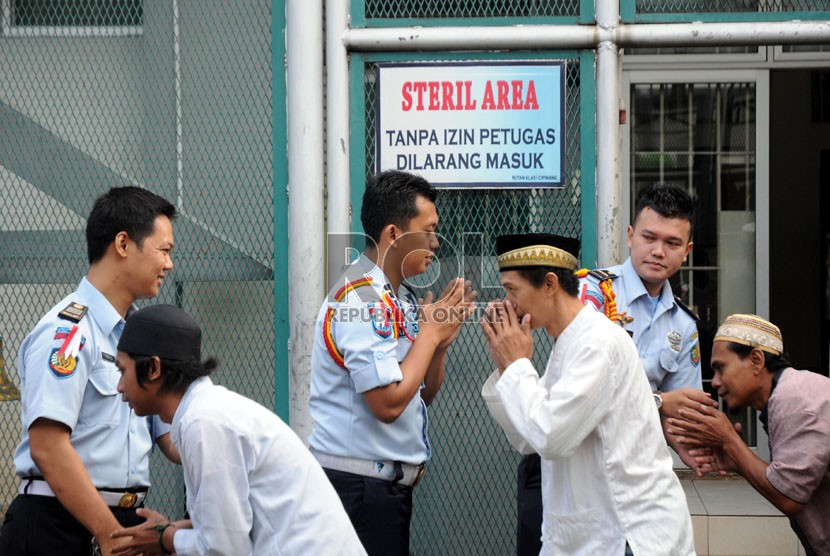  Para narapidana mengantre untuk berjabat tangan dengan petugas penjaga Rutan usai menunaikan salat Ied di lapangan Rumah Tahanan (Rutan) Kelas 1, Cipinang, Jakarta, Senin (28/7).  (Republika/Aditya Pradana Putra)