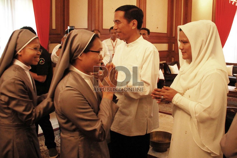  Gubernur DKI Jakarta sekaligus Presiden terpilih 2014-2019 Joko Widodo bersama istri Iriana Widodo menyalami warga saat open house di rumah dinas, Jakarta Pusat, Senin (28/7). (Republika/Yasin Habibi)