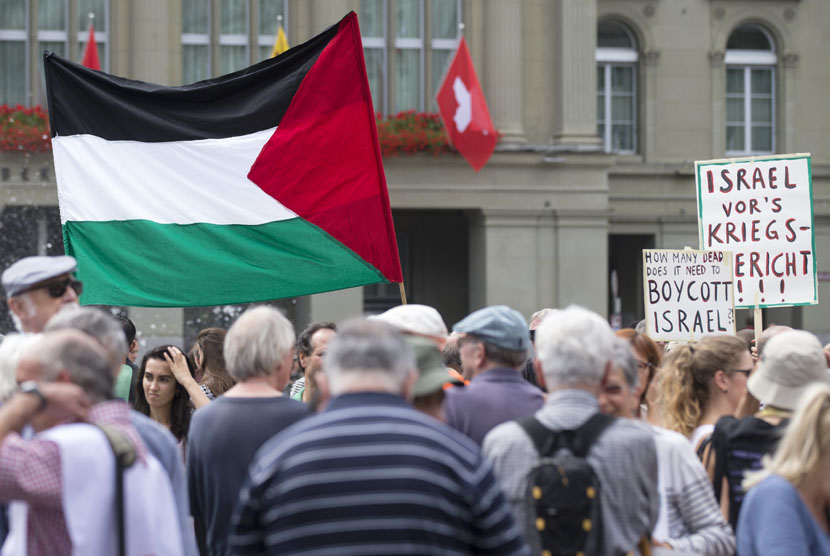   Aksi unjuk rasa dukungan bagi warga Gaza, atas serangan Israel yang memakan korban jiwa penduduk sipil, di Lapangan Bundesplatz, Bern, Swiss, Sabtu (8/2). (AP/Peter Klaunzer)