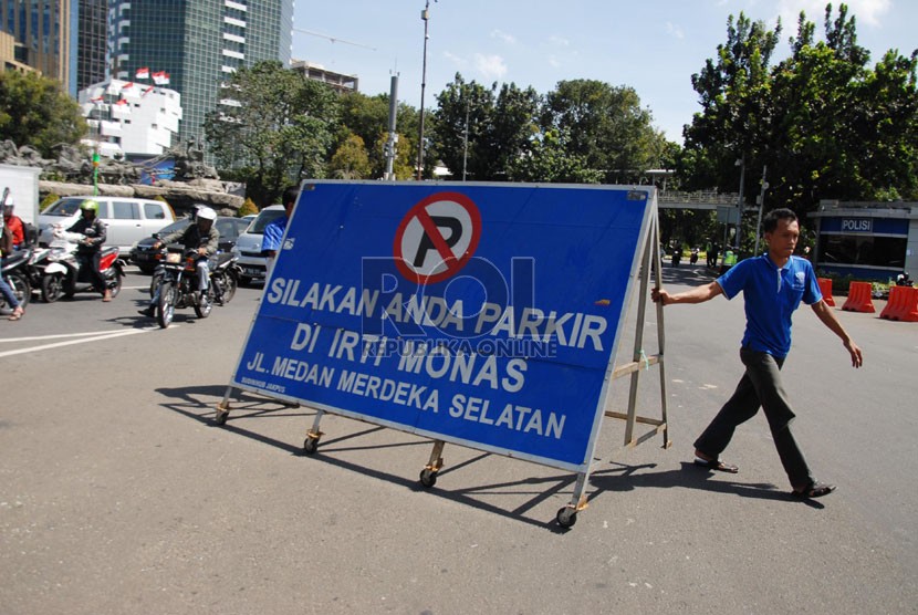  Petugas memasang rambu-rambu pengalihan arus lalu lintas di Jalan Medan Merdeka Barat, Jakarta Pusat, Rabu (6/8). (Republika/Rakhmawaty La'lang )