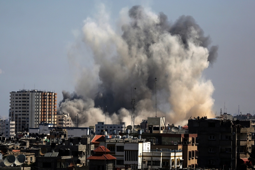  Asap mengepul dari bangunan di utara kota Gaza, Jumat (8/8), akibat serangan pertama militer Israel sejak  gencatan senjata selama tiga hari.  (EPA/Mohammed Saber)