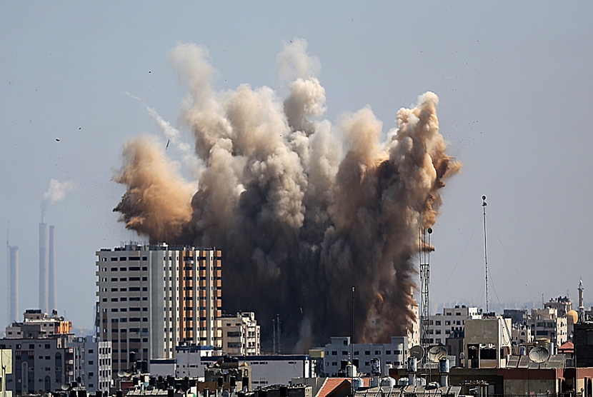  Asap mengepul dari bangunan di utara kota Gaza, Jumat (8/8), akibat serangan pertama militer Israel sejak  gencatan senjata selama tiga hari.  (EPA/Mohammed Saber)