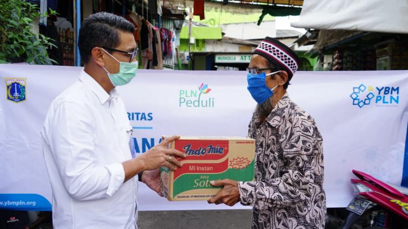 M Ikhsan Asaad, General Manager PLN Unit Induk Distribusi Jakarta Raya memberikan bantuan sembako kepada masyarakat terdampak Covid-19. .