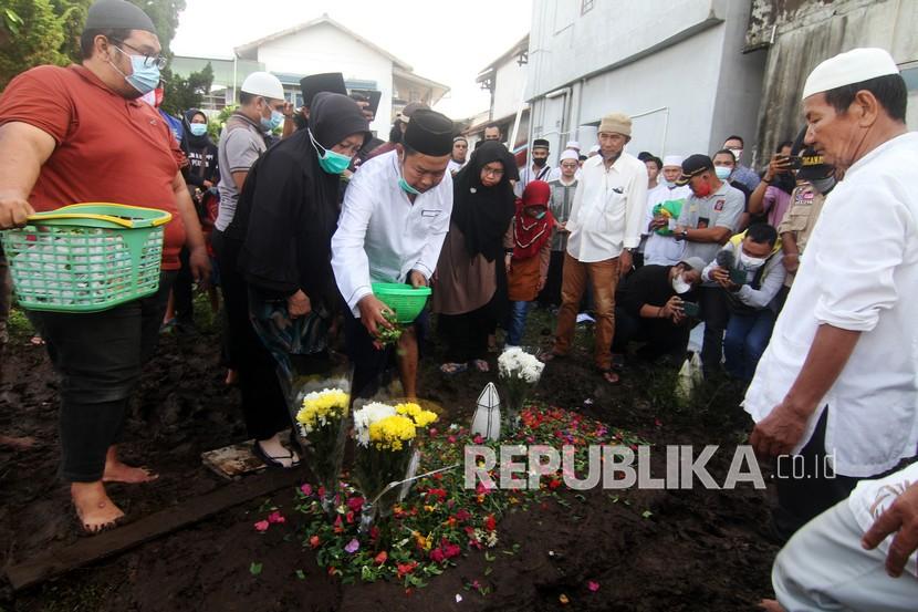 M Nasir (ketiga kiri) dan istrinya Kamsiyah (kedua kiri), orangtua dari Ihsan Adhlan Hakim, korban pesawat Sriwijaya Air menaburkan bunga di makam anaknya, di pemakaman Gang Hasanah, Jalan Tabrani Hadi, Pontianak, Kalimantan Barat, Sabtu (16/1/2021). Dua jenazah korban kecelakaan pesawat Sriwijaya Air PK-CLC nomor penerbangan SJ-182 yaitu Ihsan Adhlan Hakim dan Agus Minarni yang telah teridentifikasi dipulangkan ke Pontianak untuk diserahkan kepada keluarga dan selanjutnya langsung dimakamkan.