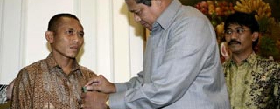M Rahman menerima lencana dari Presiden RI