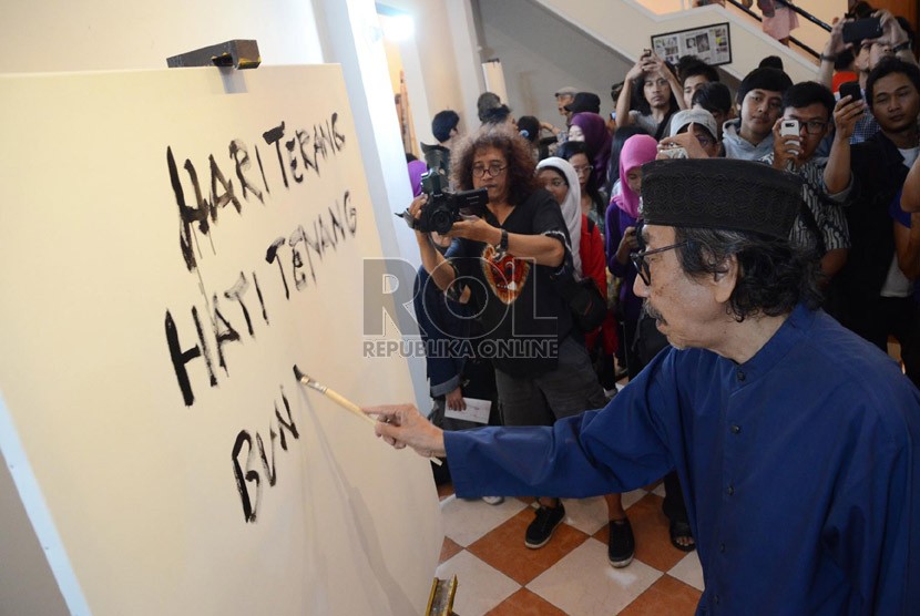 Maestro lukis Jeihan Sukmantoro melukiskan puisinya pada pembukaan pameran lukisan dan puisi 'Lima Rukun' di Studio Jeihan, Bandung, Sabtu (28/9). (Republika/Edi Yusuf)