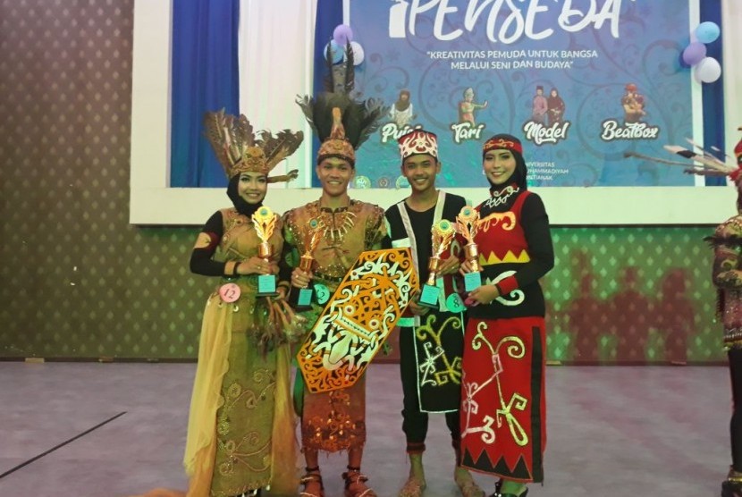 Mahasiswa AMIK BSI Pontianak, Satriansyah (kedua dari kiri) dan Fitri Febriyani (kiri) menjadi juara pertama lomba pakaian adat tingkat Provinsi Kalimantan Barat.    