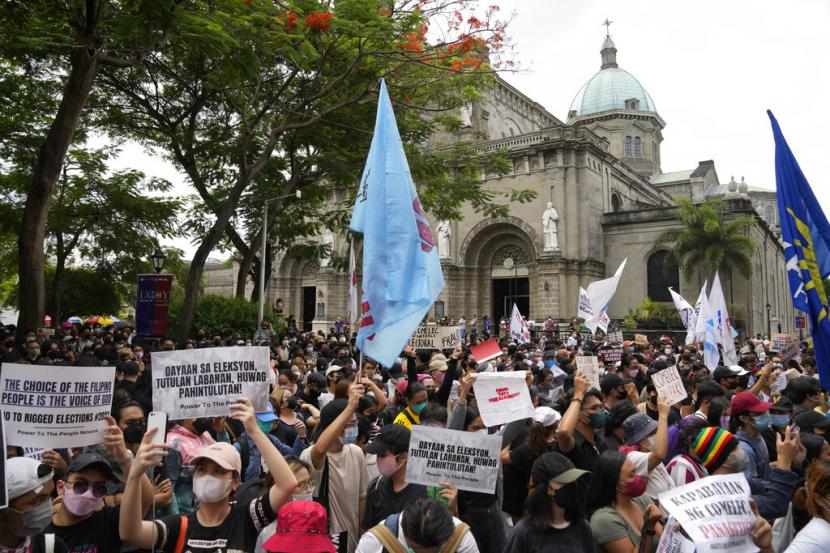Mahasiswa dan aktivis memegang slogan-slogan selama rapat umum di depan kantor Komisi Pemilihan Umum saat mereka mempertanyakan hasil pemilihan presiden di Manila, Filipina pada Selasa 10 Mei 2022. 