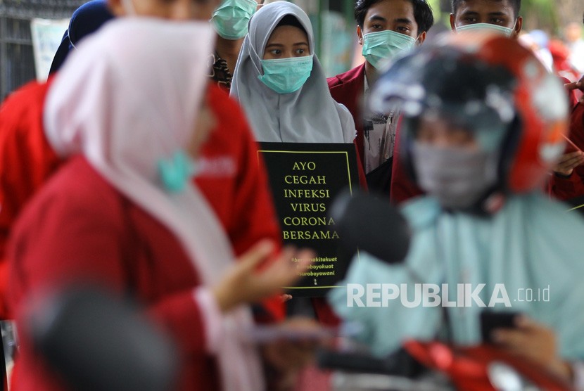 Mahasiswa Fakultas Ilmu Kesehatan (FIK) Universitas Muhammadiyah Surabaya membawa poster saat melakukan aksi sosialisasi bahaya virus Corona di Surabaya, Jawa Timur, Jumat (31/1/2020).