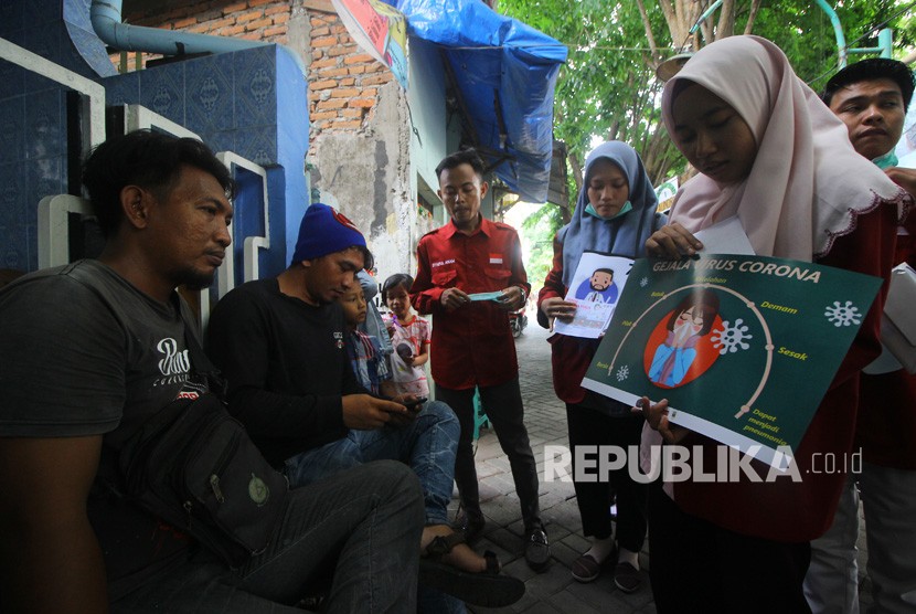 Mahasiswa Fakultas Ilmu Kesehatan (FIK) Universitas Muhammadiyah Surabaya memberi penjelasan kepada warga akan bahaya virus Corona di Surabaya, Jawa Timur, Jumat (31/1/2020). 