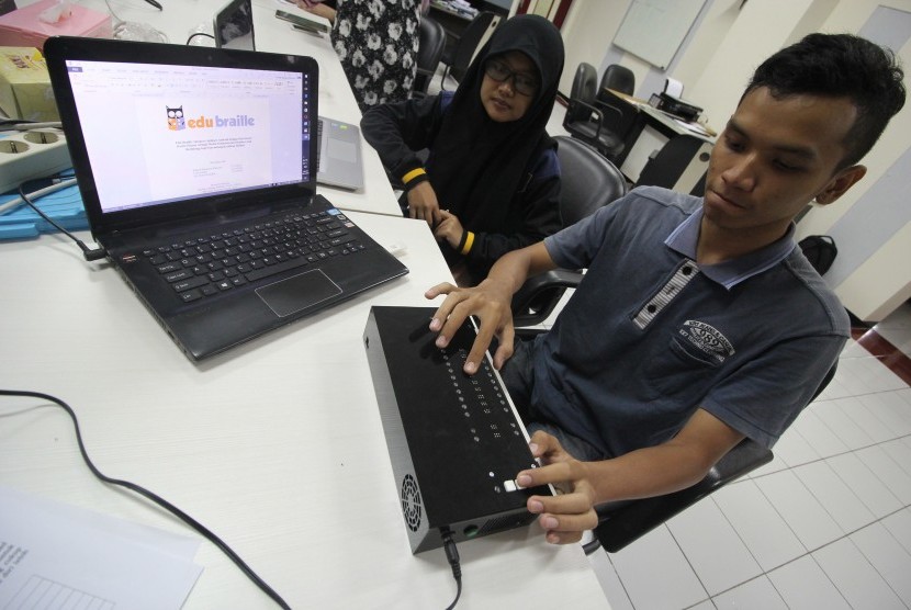 Mahasiswa jurusan teknik mesin ITS, Rahmat Bambang Wahyuari (kanan) dan Mahasiswi teknik informatika ITS, Nida Amalia (kiri) memperlihatkan cara kerja Edu Braille saat jumpa pers di Surabaya, Jawa Timur, Jumat (21/10). 
