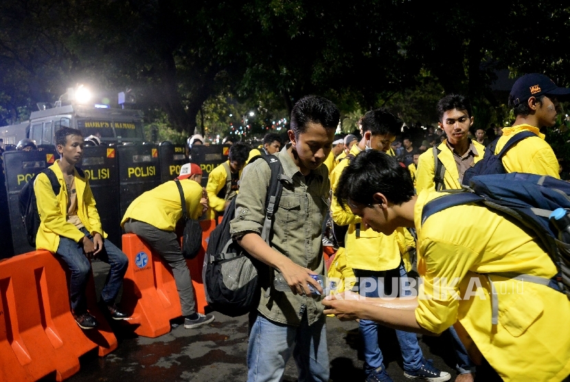  Mahasiswa membantu rekannya untuk berwudhu sebelum melakukan Sholat Isya saat aksi bela rakyat 121 di depan Istana Merdeka, Jakarta,Kamis (12/1).