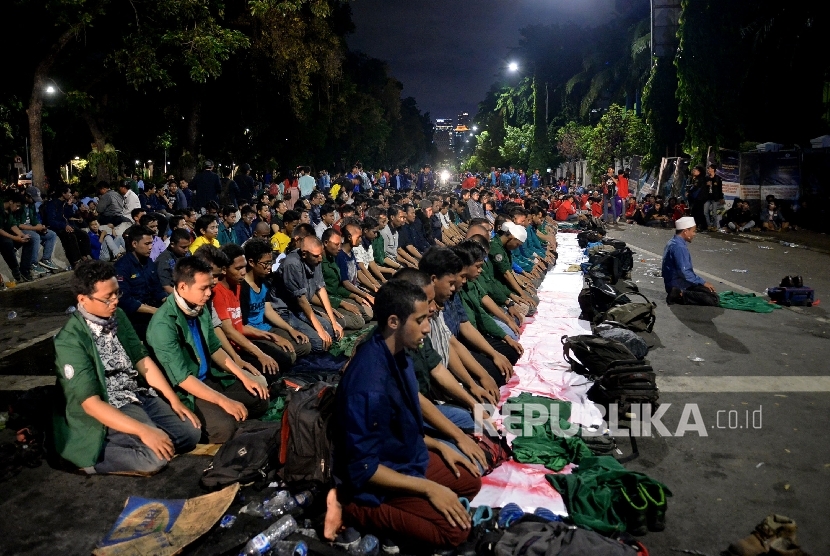  Sejumlah mahasiswa yang tegabung dalam aliansi BEM Se-Indonesia melakukan Sholat Isya saat aksi bela rakyat 121 di depan Istana Merdeka, Jakarta,Kamis (12/1).