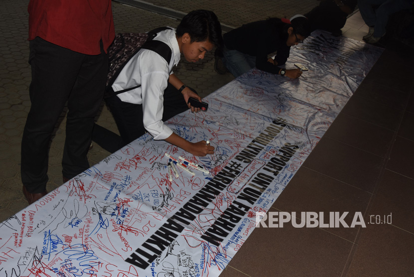 Mahasiswa membawa karangan bunga yang berisi dukungan kepada mahasiswa berkebutuhan khusus korban bullying berinisial MF di depan gedung rektorat Kampus Gunadarma, Depok, Jawa Barat, Senin (17/7). 