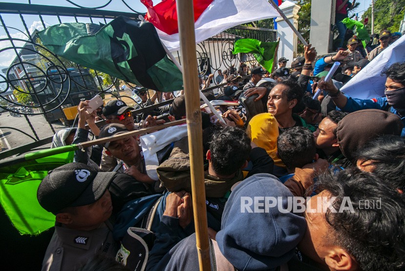 Mahasiswa terlibat aksi dorong-dorongan dengan aparat keamanan pada unjuk rasa menolak RUUKUHP di depan Kantor DPRD Sulawesi Tengah di Palu, Selasa (24/9/2019). 