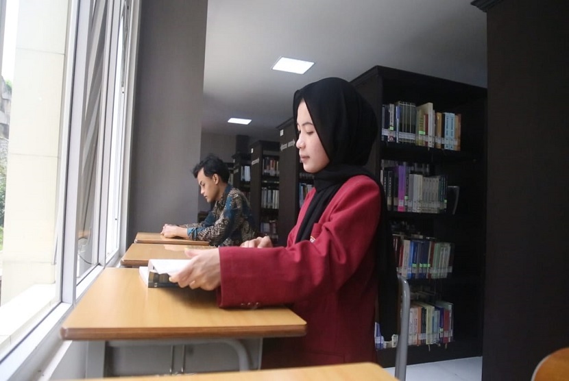 Mahasiswa Universitas Muhammadiyah Malang (UMM), Sherly Lola Zuraida tengah membaca buku di salah satu ruangan di UMM. 