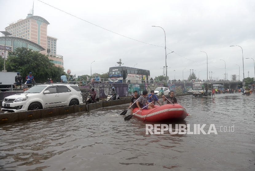 Mahasiswa Universitas Tarumanegara menggunakan perahu karet saat banjir di kawasan Grogol, Jakarta Barat, Selasa (21/2).