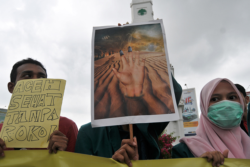  Mahasiswa yang tergabung dalam Aliansi Pemuda Aceh Anti Rokok (APAR) membawa poster dan spanduk saat aksi memperingati Hari Tanpa  Tembakau Sedunia di Bundaran Simpang Lima, Banda Aceh, Ahad (31/5). (Antara/Ampelsa)