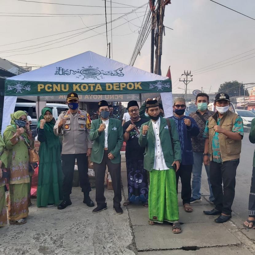 Majelis Wakil Cabang (MWC)  NU Kecamatan Bojongsari, Kota Depok membagikan  2.000 masker dan 2.000 paket buka puasa kepada pengguna jalan raya.
