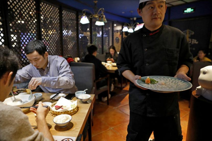 Makan bersama. Warga China terbiasa mengambil makanan yang dihidangkan dengan sumpit yang sama dengan yang dipakainya untuk memasukkan makanan ke mulutnya.