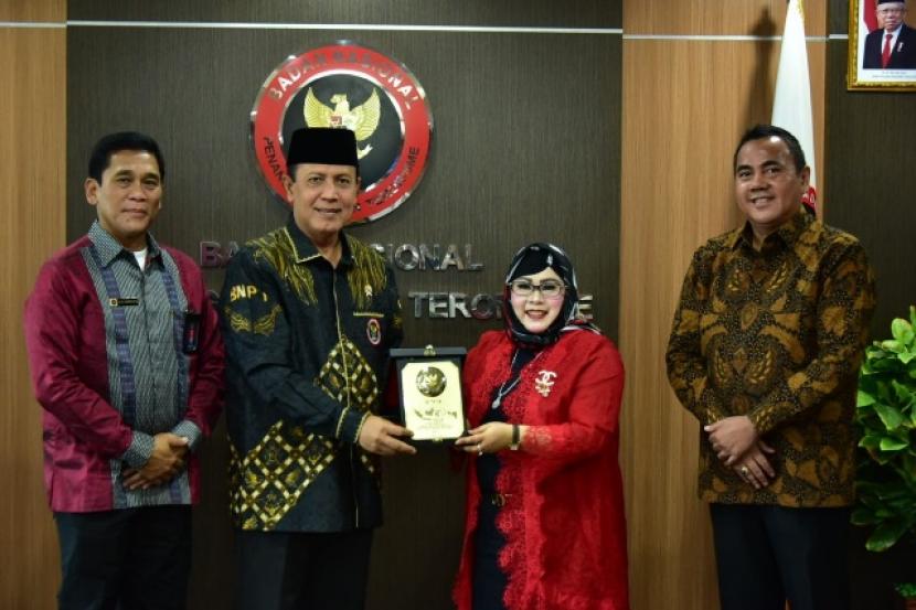  Kepala BNPT RI, Komjen Pol Boy Rafli Amar (kedua kiri) bertukar cenderamata dengan Pembina Yayasan Dewa Dewi Indonesia, putri kedua Wakil Presiden, Hj Siti Mamduhah Ma'ruf Amin.   
