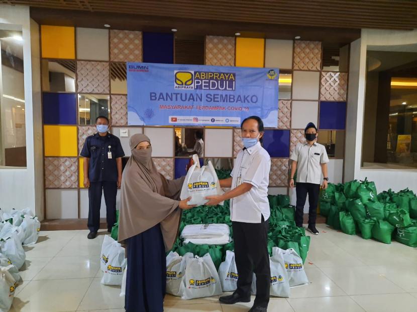 Manager Program Kemitraan dan Bina Lingkungan Brantas Abipraya Rudi Pudianto (kanan) menyerahkan bantuan sembako kepada perwakilan salah satu warga di sekitar Cawang, Jakarta, Senin (18/5).