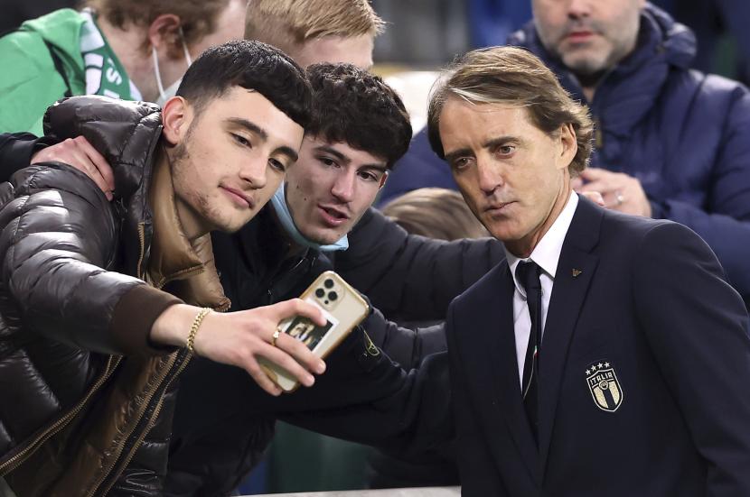 Manajer Italia Roberto Mancini berfoto dengan para penggemar setelah pertandingan sepak bola kualifikasi grup C Piala Dunia 2022 antara Irlandia Utara dan Italia di stadion Windsor Park di Belfast, Irlandia Utara, beberapa waktu lalu.