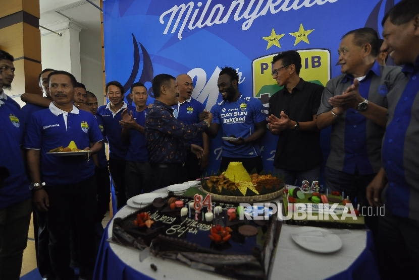 Manajer Persib, Umuh Muchtar menyerahkan kue kepada Michael Essien saat ikut merayakan ulang tahun Persib Bandung ke-84 di Graha Persib, Jalan Sulanjana, Kota Bandung, Selasa (14/3)