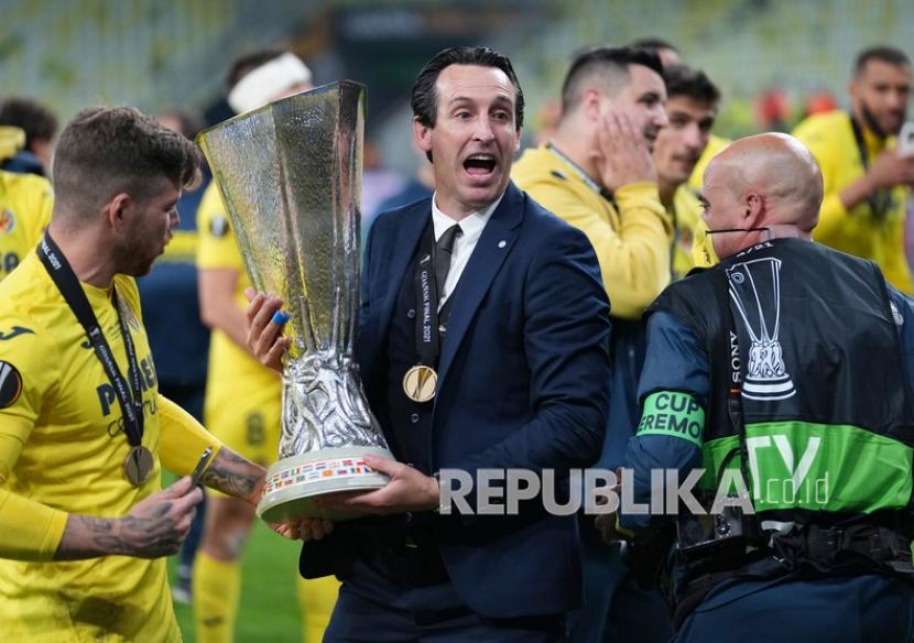 Manajer Villareal Unai Emery memegang trofi saat ia merayakan dengan para pemainnya setelah memenangkan pertandingan sepak bola final Liga Europa antara Manchester United dan Villarreal di Gdansk, Polandia,  Kamis (27/5) dini hari WIB.