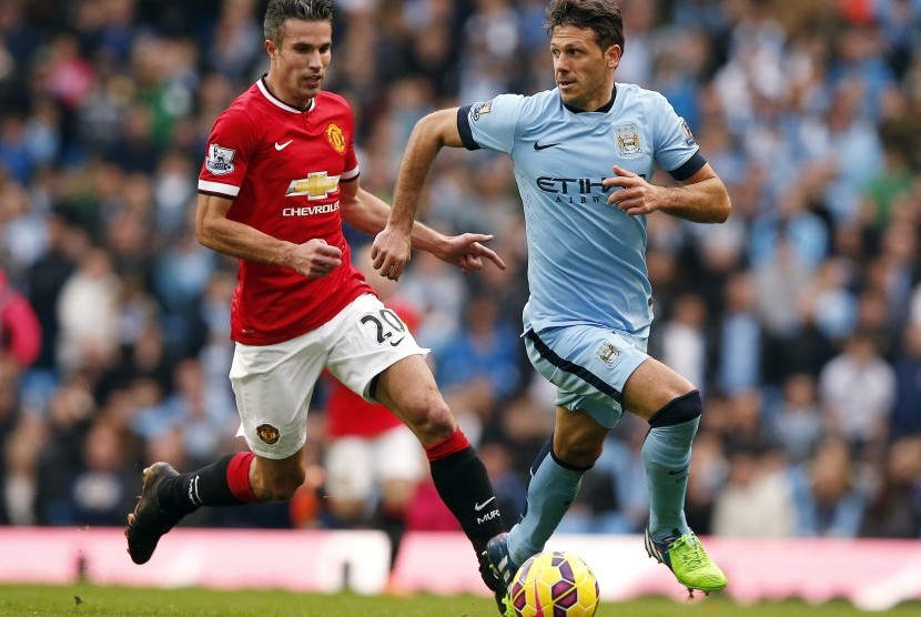 Manchester City's Martin Demichelis (R) is chased by Manchester United's Robin van Persie during their English Premier League soccer match at the Etihad Stadium in Manchester, northern England November 2, 2014