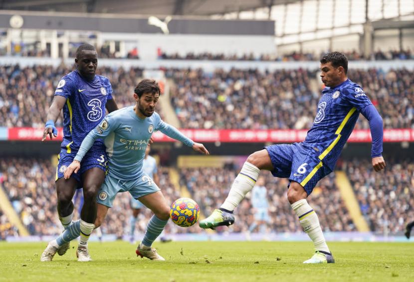 Gelandang Manchester City Bernardo Silva (tengah) dijaga bek Chelsea Thiago Silva (kanan) dan Malang Sarr dalam pertandingan Liga Primer Inggris di Stadion Etihad, Sabtu (15/1/2022)..